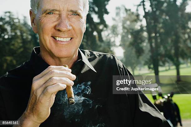 man smoking a cigar - cigar stock-fotos und bilder