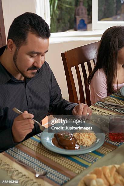 man eating chicken in mole sauce - mole sauce fotografías e imágenes de stock