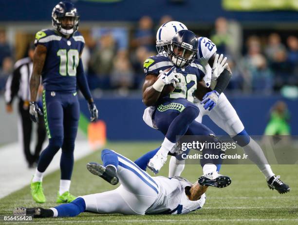 Running back Chris Carson of the Seattle Seahawks is tackled by Vontae Davis of the Indianapolis Colts and Matthias Farley in the second quarter of...