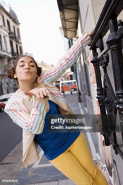 woman hanging from railing blowing a kiss - blowing kiss stock pictures, royalty-free photos & images