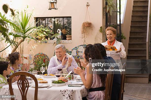 family sitting at dining table - argentina traditional food stock pictures, royalty-free photos & images