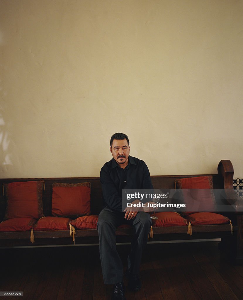 Seated man holding glass of wine