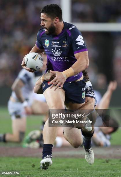 Jesse Bromwich of the Storm breaks through Cowboys tackles as Shaun Fensom of the Cowboys is injured during the 2017 NRL Grand Final match between...