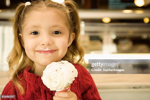 happy girl holding ice cream cone - girl eating messy ice cream cone stock-fotos und bilder