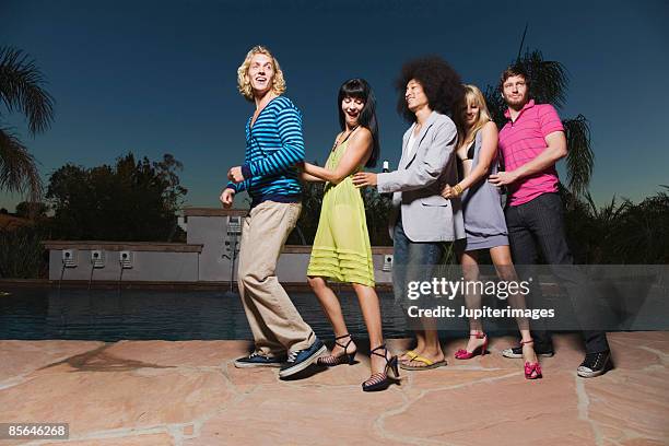 friends dancing in conga line - pool party night stock pictures, royalty-free photos & images