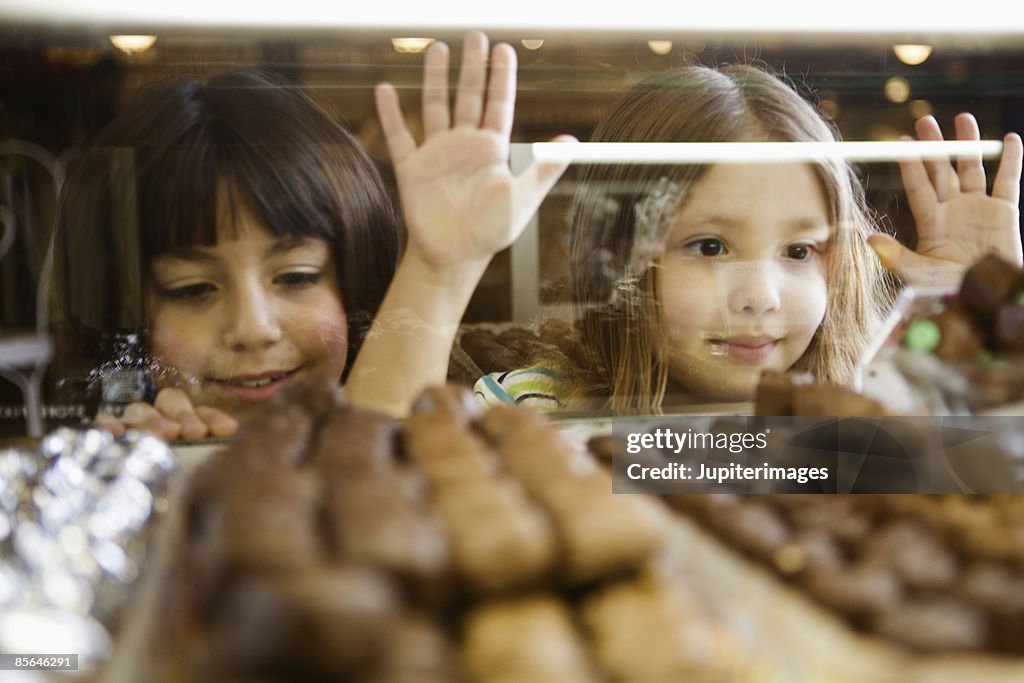 Girls pining for candy in display case