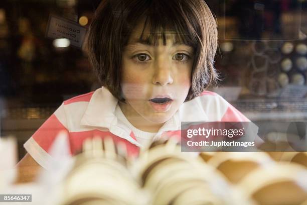 girl awed by chocolate bonbons in glass case - starren stock-fotos und bilder