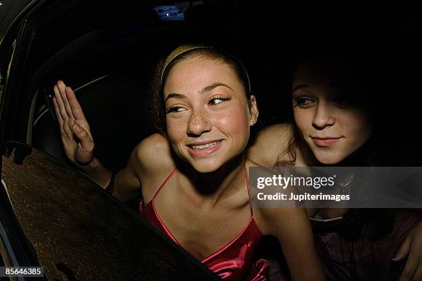 teenage girls looking out of limo window - going home night stock-fotos und bilder