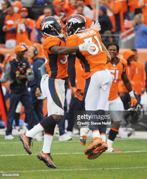Denver Broncos safety Will Parks, left, celebrates Justin Simmons' interception of Oakland Raiders quarterback E.J. Manual to seal the victory in the...