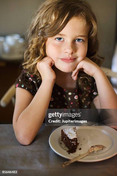 girl sitting in front of slice of chocolate cake - chocolate souffle stock pictures, royalty-free photos & images