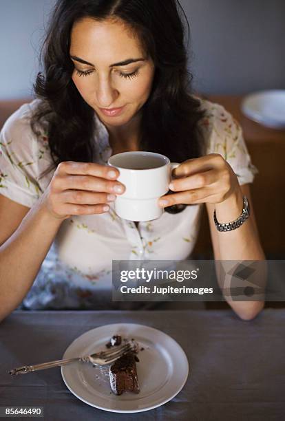 woman sitting in front of slice of chocolate cake - chocolate souffle stock pictures, royalty-free photos & images