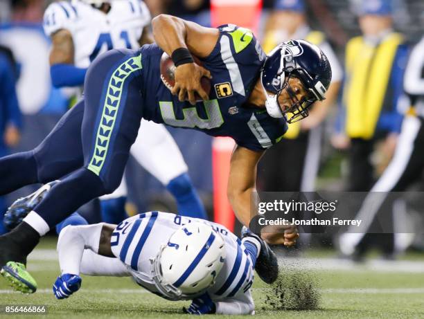 Quarterback Russell Wilson of the Seattle Seahawks scrambles over Darius Butler of the Indianapolis Colts for a touchdown in the third quarter of the...