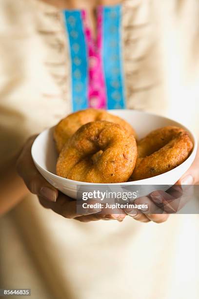 woman holding plate of medu vadas - medu vada stock pictures, royalty-free photos & images