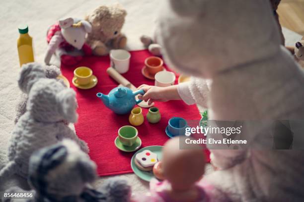 child (4-5) in cozy hooded bear costume, having a teddy bears' picnic - bambola giocattolo foto e immagini stock