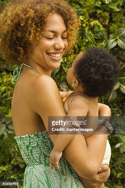 smiling woman holding baby - reusable diaper stock pictures, royalty-free photos & images