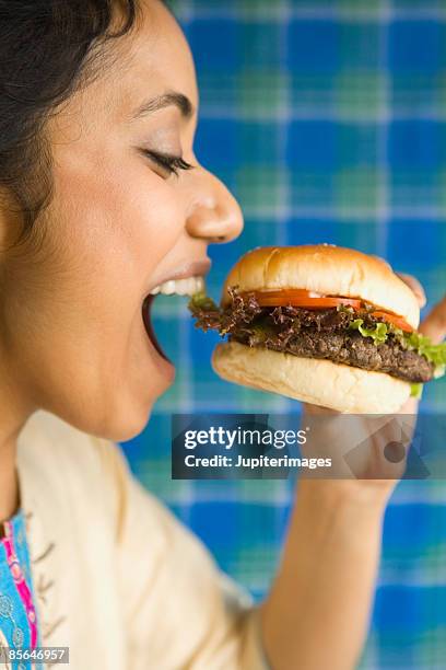 woman eating burger - woman eating burger stockfoto's en -beelden