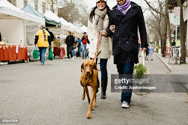 couple with dog at farmer's market - couple walking shopping stock pictures, royalty-free photos & images