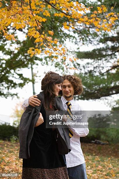 man putting jacket on woman - gentleman stock-fotos und bilder