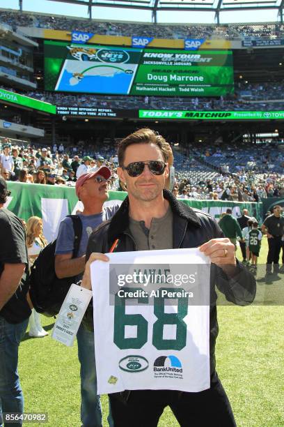 Hugh Jackman poses on the sideline with a towel honoring former New York Jets Center Kevin Mawae when he attends the Jacksonville Jaguars vs New York...