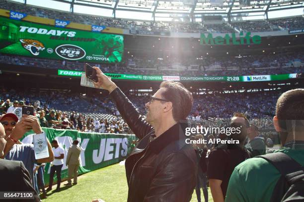 Hugh Jackman takes cellphone photos on the sideline when he attends the Jacksonville Jaguars vs New York Jets game at MetLife Stadium on October 1,...