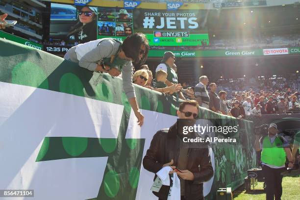 Hugh Jackman signs an autograph for a fan when he attends the Jacksonville Jaguars vs New York Jets game at MetLife Stadium on October 1, 2017 in...