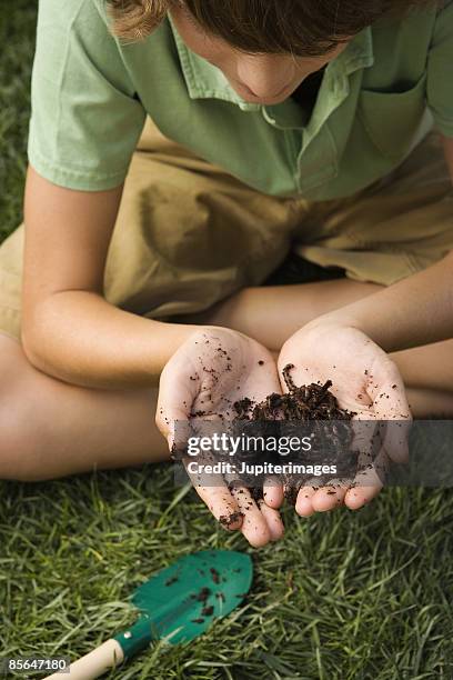 teen boy with handful of dirt - earthworm stock-fotos und bilder