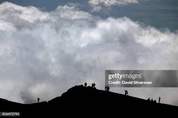 Visitors walk along the rim of a crater on the Mt. Etna volcano, Europe's largest and most active, on September 22, 2017 in Sicily, Italy. Wine has...