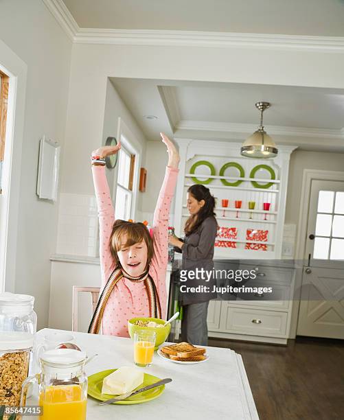 girl stretching at breakfast table - yawning mother child stock pictures, royalty-free photos & images
