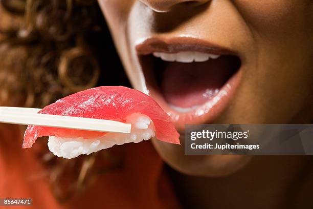 woman eating nigiri sushi - nigiri fotografías e imágenes de stock