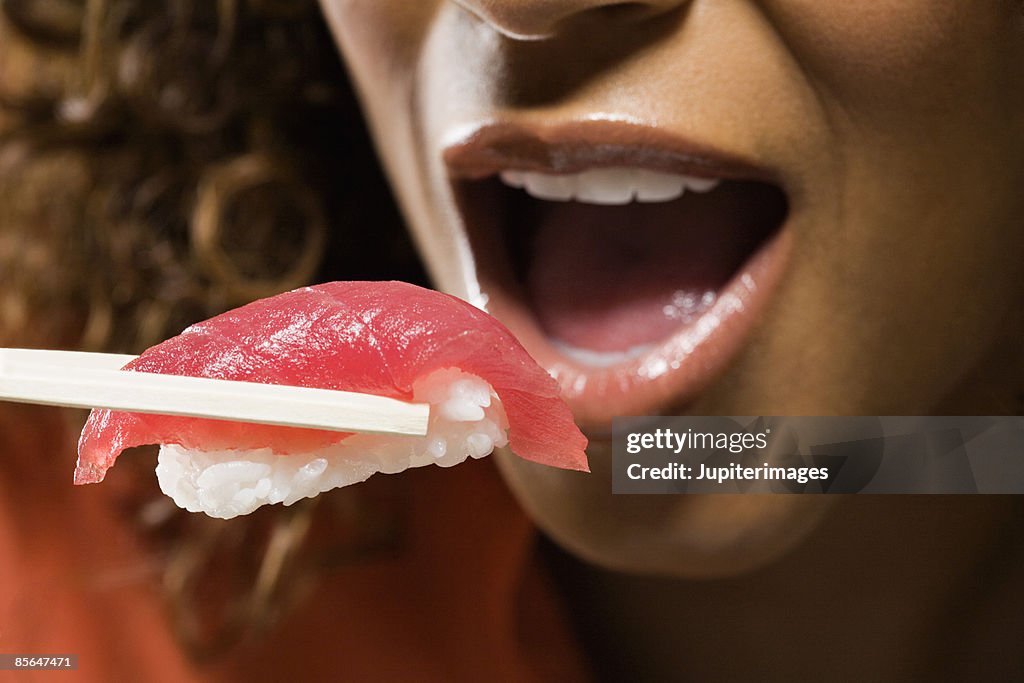 Woman eating nigiri sushi