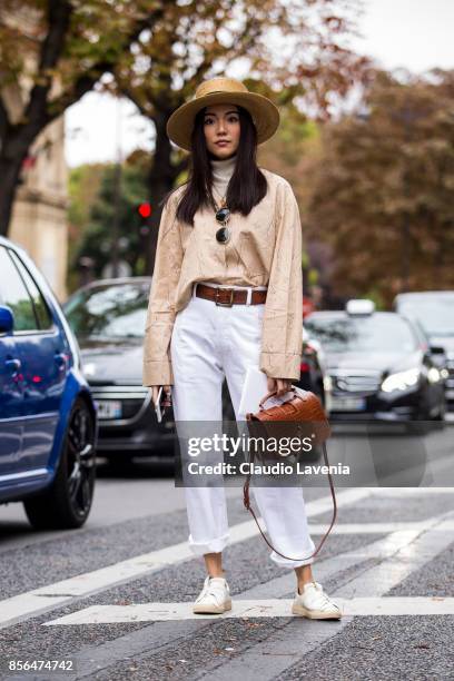 Yoyo Cao wearing white pants and a straw hat is seen before the Valentino show during Paris Fashion Week Womenswear SS18 on October 1, 2017 in Paris,...