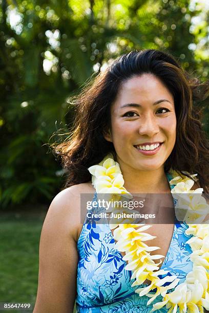 smiling woman with flower leis - lei day hawaii stock pictures, royalty-free photos & images