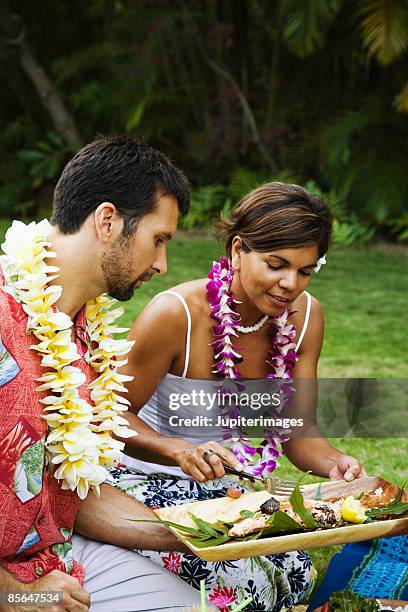 man and woman at hawaiian picnic - lei day hawaii stock-fotos und bilder