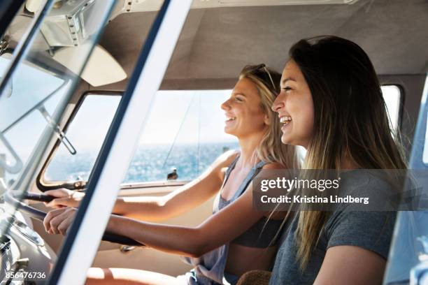 group of friends with a surf van by the sea - personentransporter stock-fotos und bilder