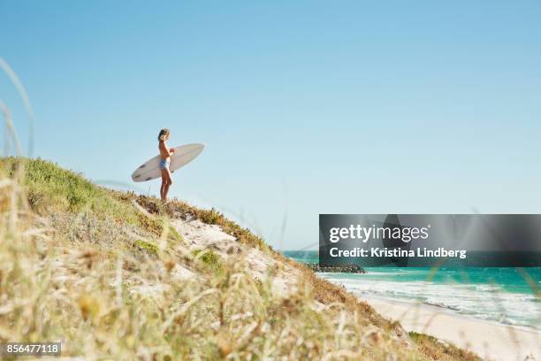 woman on hill with surfboard looking to the sea - perth fotografías e imágenes de stock