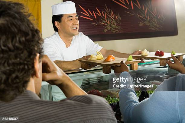 sushi chef serving sushi - sushi chef stock pictures, royalty-free photos & images