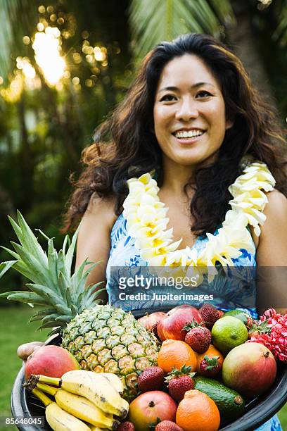 woman holding platter of fruit - lei day hawaii stock-fotos und bilder