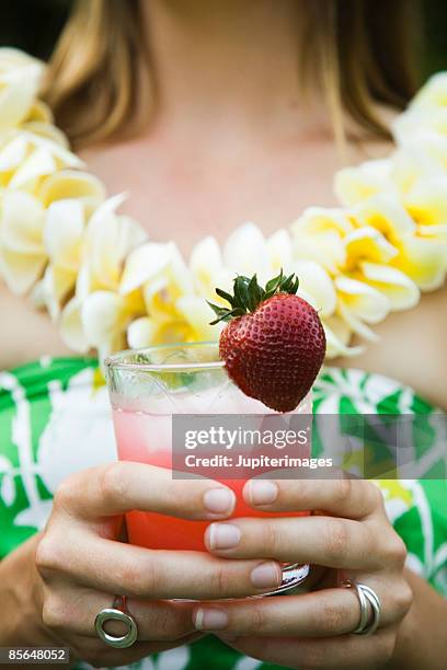 woman holding glass of juice with strawberry - strawberry juice stock pictures, royalty-free photos & images