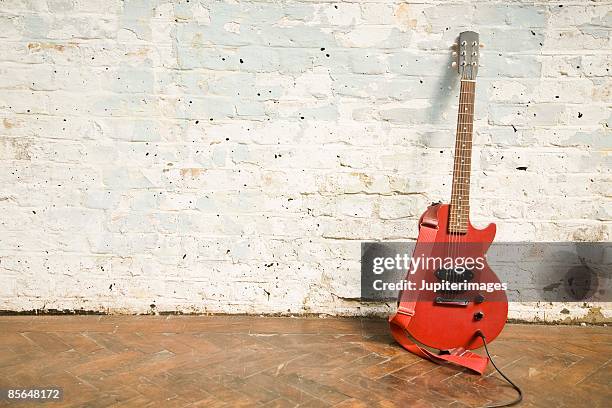 electric guitar against brick wall - elektrogitarre stock-fotos und bilder