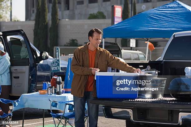 man with cooler at tailgate party - grille fotografías e imágenes de stock