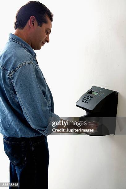 worker punching timecard - time clock stock pictures, royalty-free photos & images