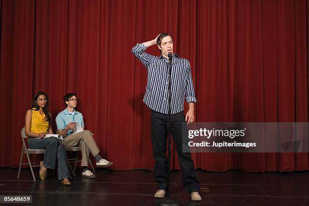 man standing on stage scratching head - stage fright stock pictures, royalty-free photos & images