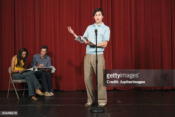 man speaking in front of microphone - audition stockfoto's en -beelden