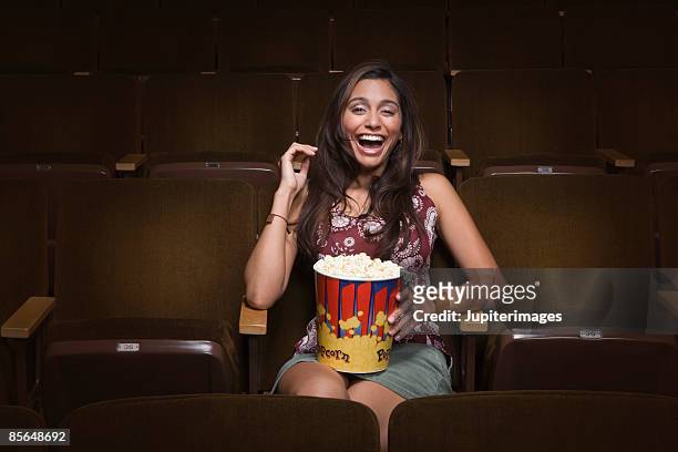 woman laughing in movie theatre - auditoria stockfoto's en -beelden