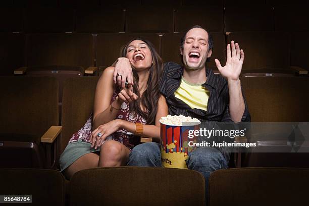 laughing couple in movie theatre - auditoria stockfoto's en -beelden
