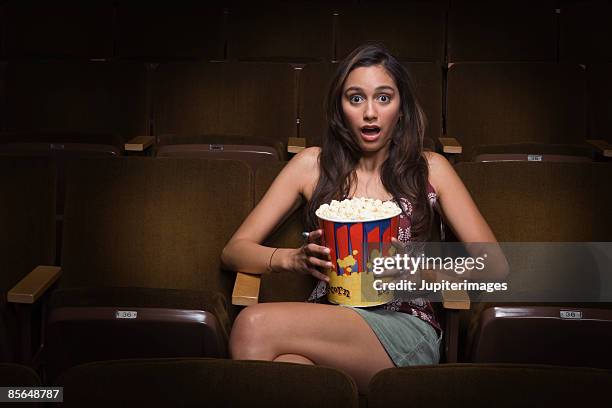 scared woman sitting in movie theater - biosalong bildbanksfoton och bilder