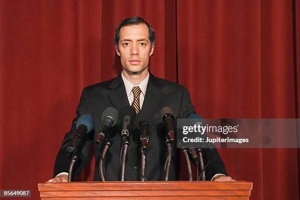 man standing at podium - politician stock pictures, royalty-free photos & images
