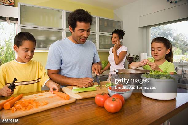 family preparing salad - bruder schwester kochen stock-fotos und bilder