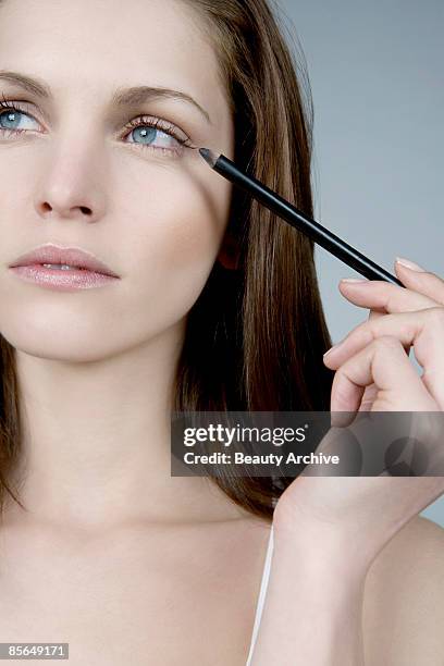 woman applying eyeliner - eye make up stock pictures, royalty-free photos & images