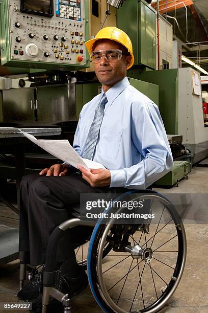 man in wheelchair wearing hardhat - casco de trabajo fotografías e imágenes de stock